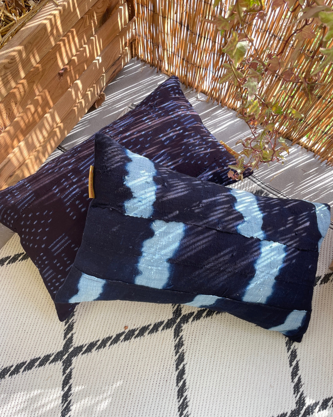 coussin bleu indigo sur un tapis à l'extérieur -indigo blue cushion on a rug outside