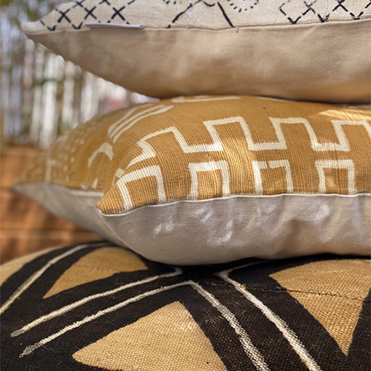 Coussin empilé l'un sur l'autre de couleurs ocre avec des motifs géométriques de couleurs blancs écrus - Cushion stacked one on top of the other in ocher colors with geometric patterns in off-white colors