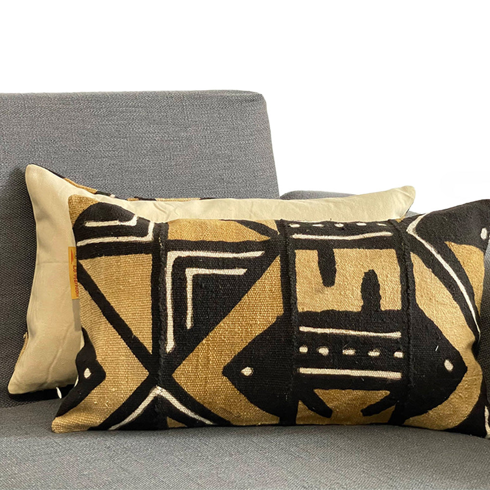 coussin en bogolan avec des formes géométriques sur canapé gris 